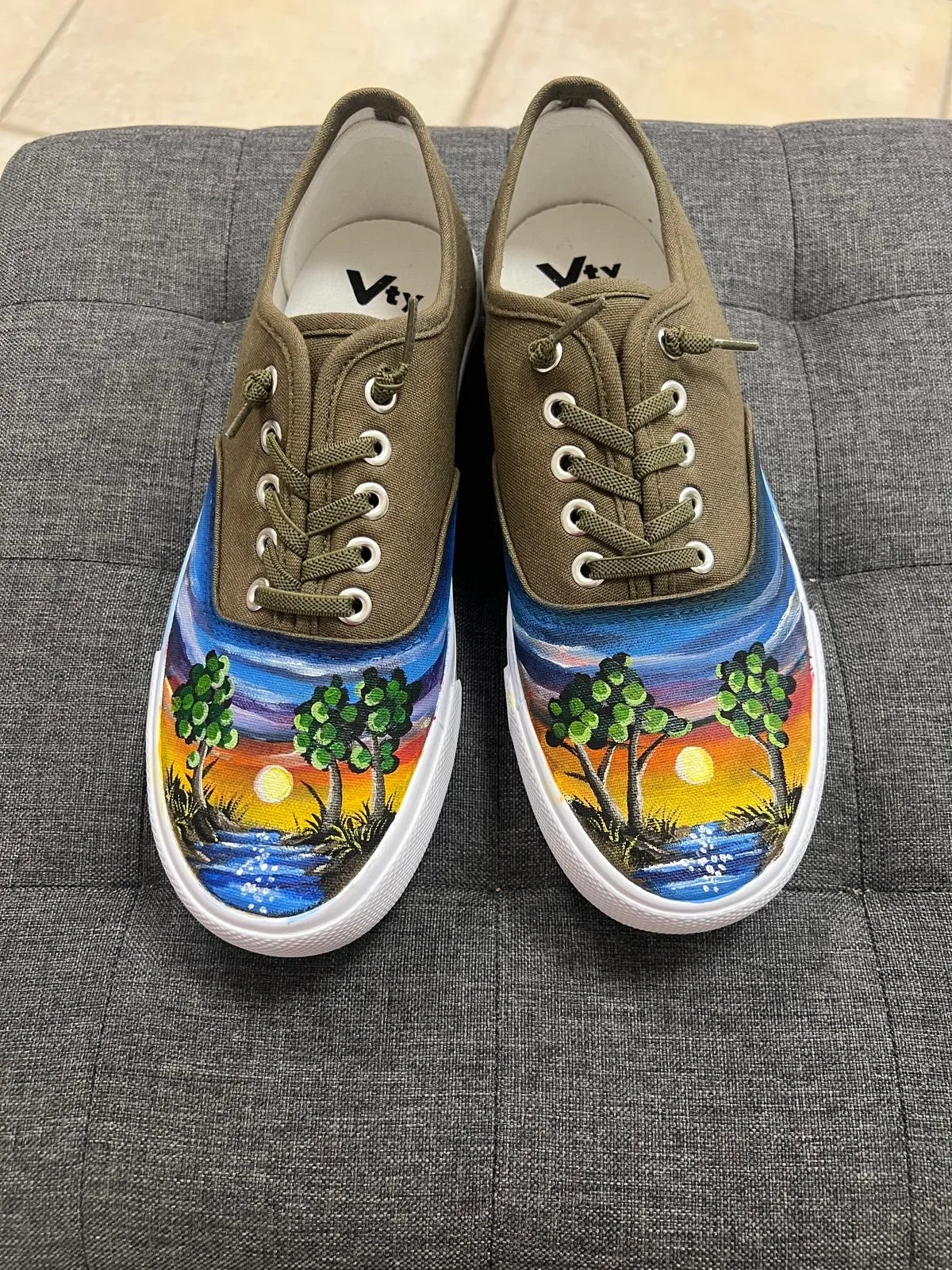 Olivgrüne Sneaker mit gemaltem Sonnenuntergang, Bäumen und Wasser
