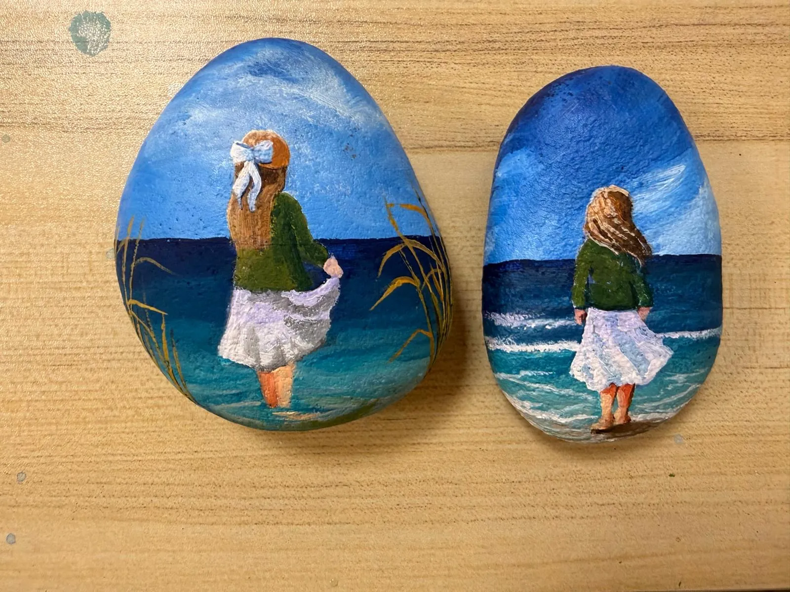 Bemalte Ostseesteine mit einem Mädchen am Wasser
